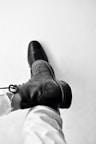person wearing black leather boots