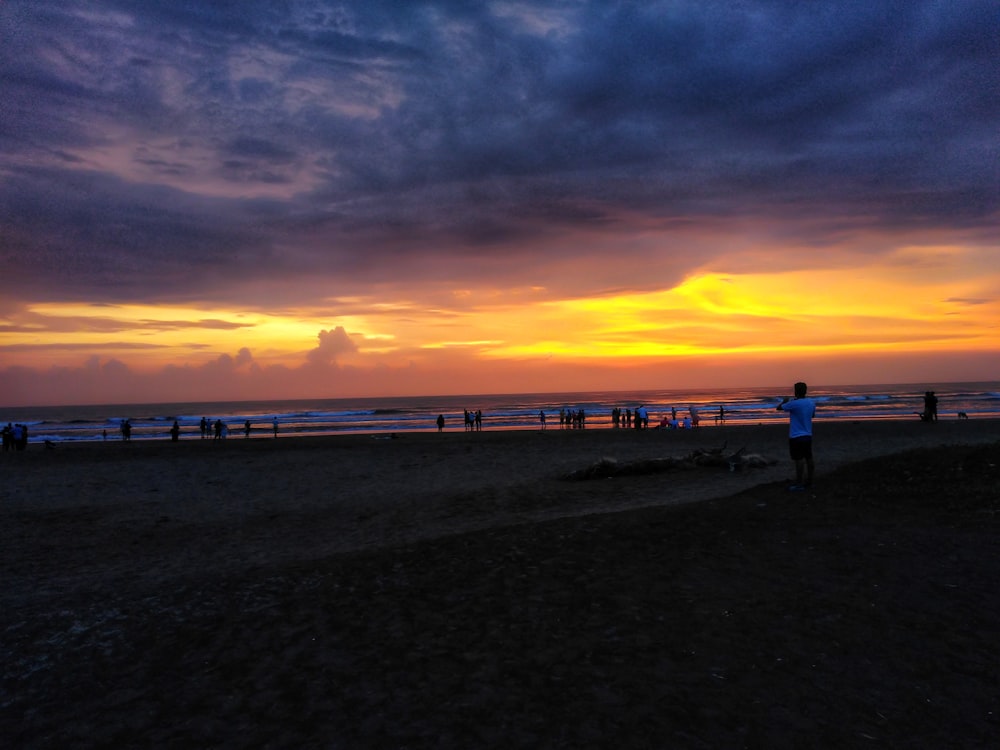 silhouette of people on beach during sunset