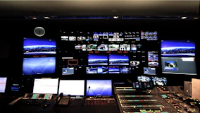 Security control room with multiple surveillance screens displaying live footage.