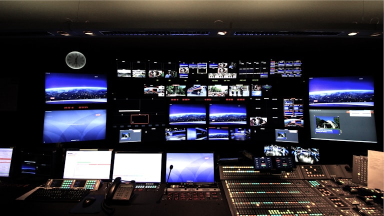 A neat arrangement of CCTV monitors displaying different camera views in a control room.