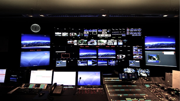 Security personnel monitoring multiple surveillance screens in a control room.