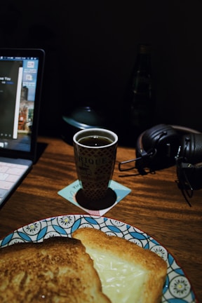 A cozy workspace with a laptop, notebook, and a cup of tea, reflecting a blogger's daily routine.