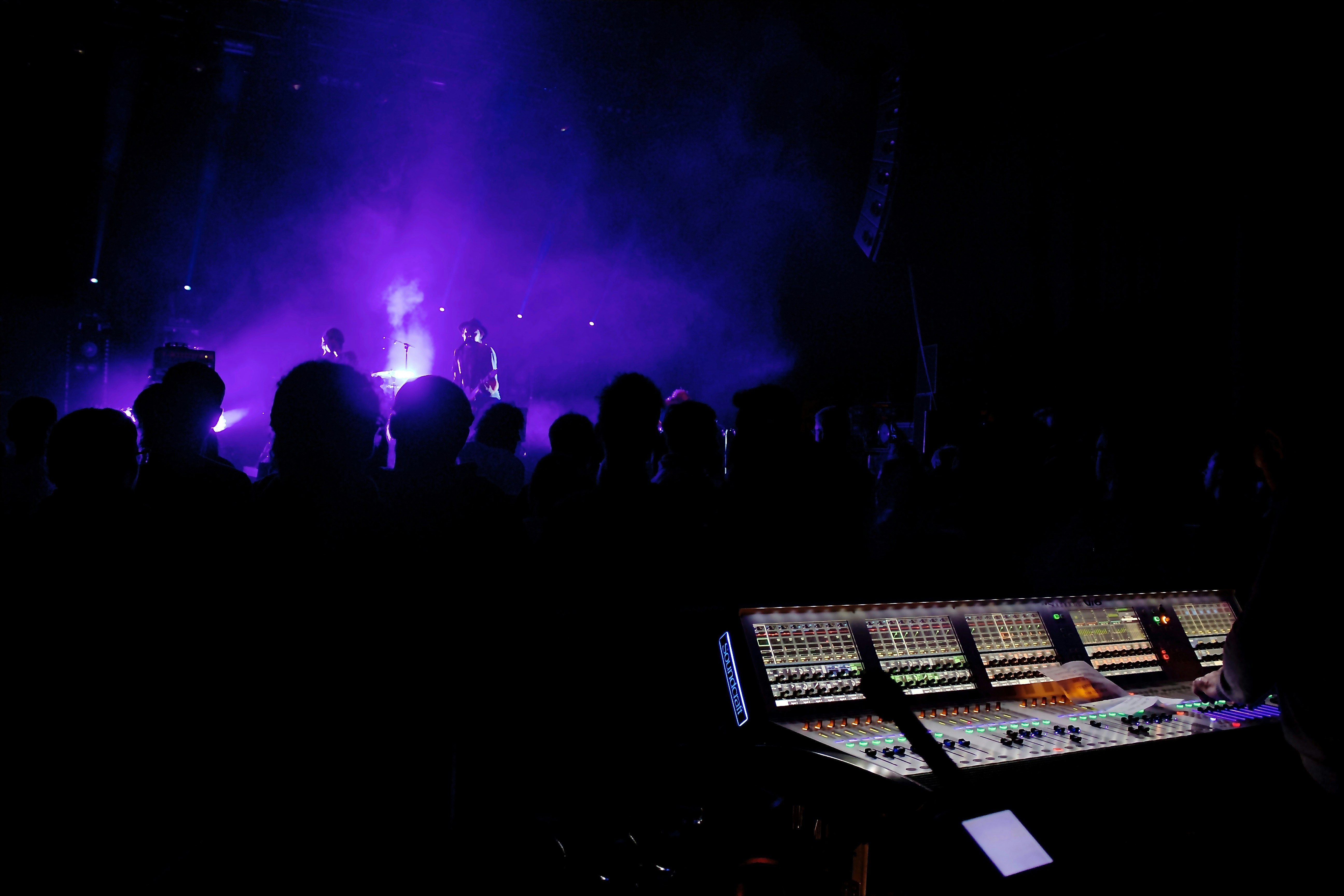 people standing on stage with lights turned on during night time