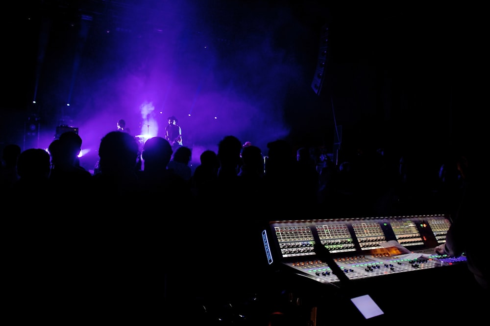 people standing on stage with lights turned on during night time