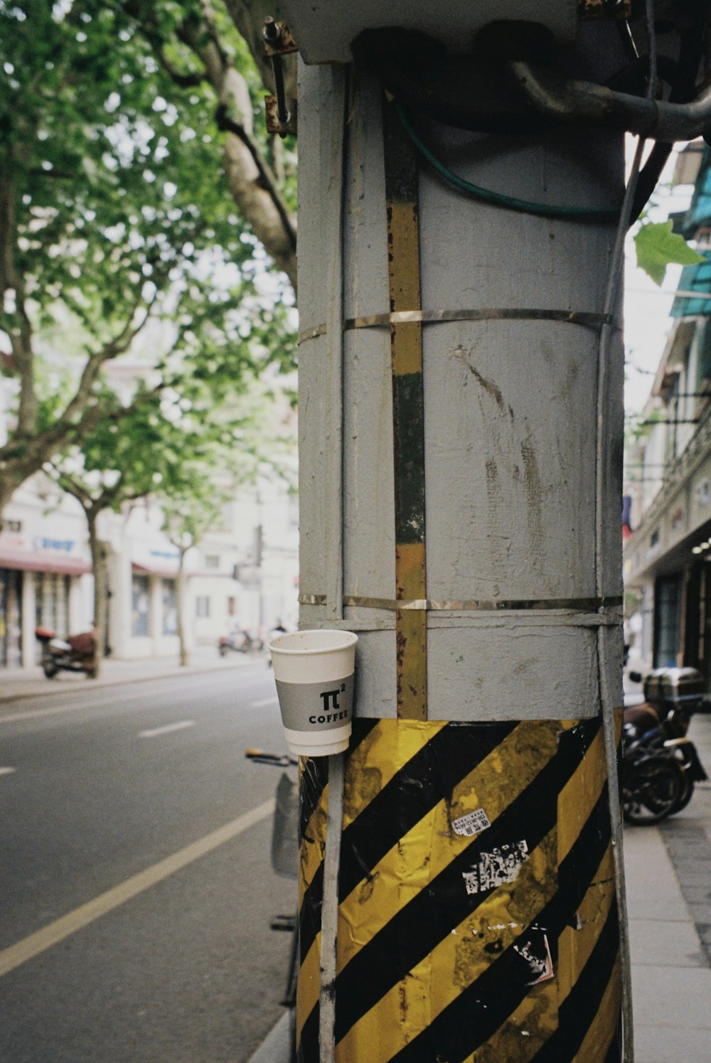 white and black trash bin beside gray concrete post