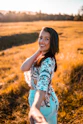 girl in blue and white floral dress standing on brown grass field during daytime