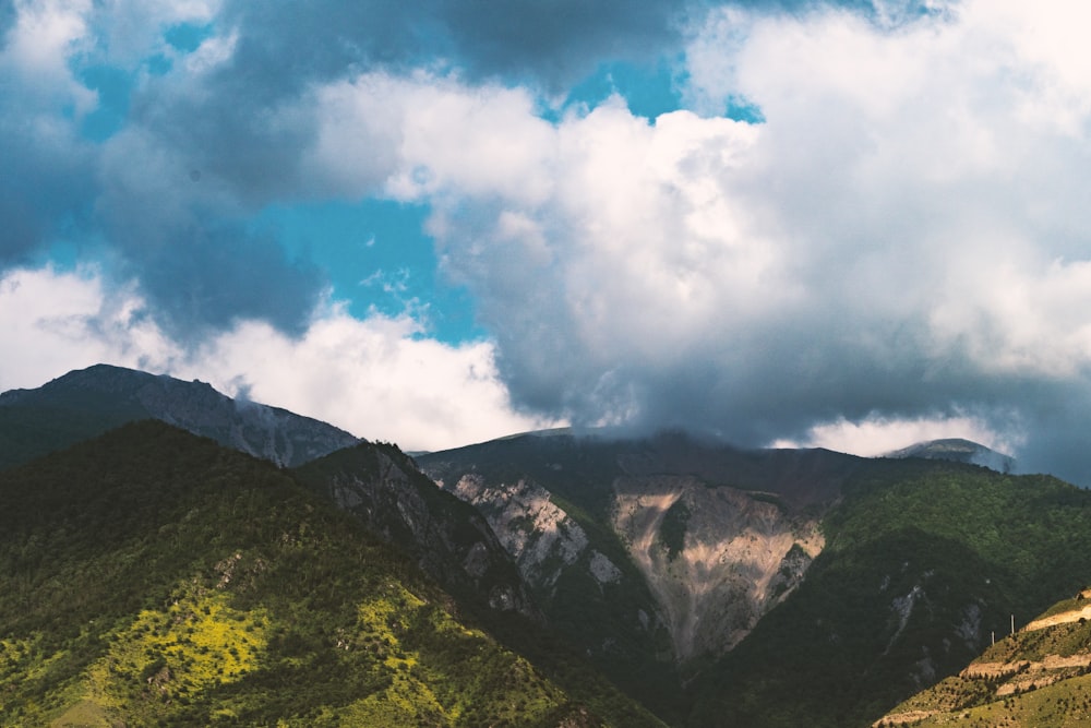 green mountains under white clouds and blue sky during daytime