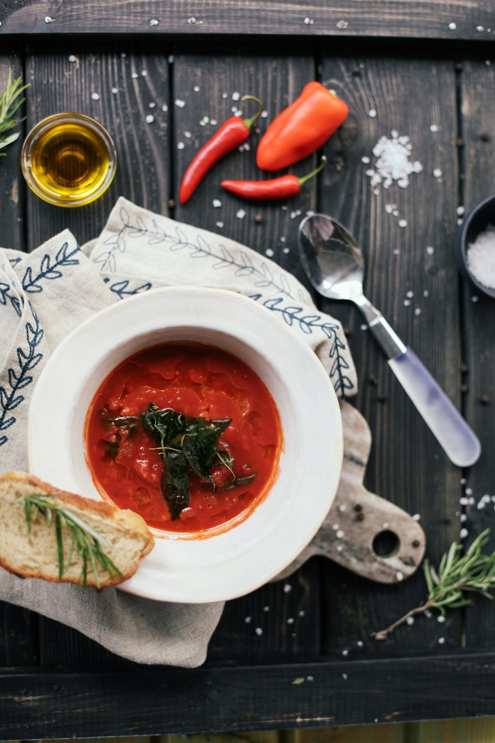 soup in white ceramic bowl beside stainless steel fork and bread knife