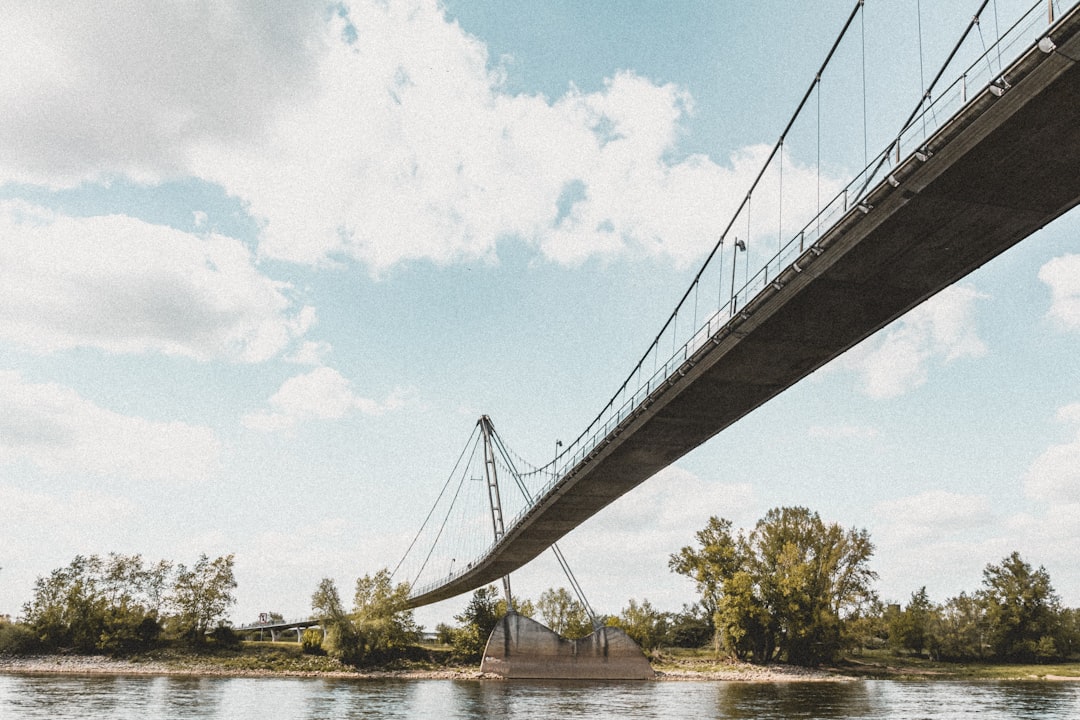 white bridge over river under white clouds during daytime