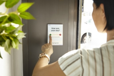 person holding white card near green plant