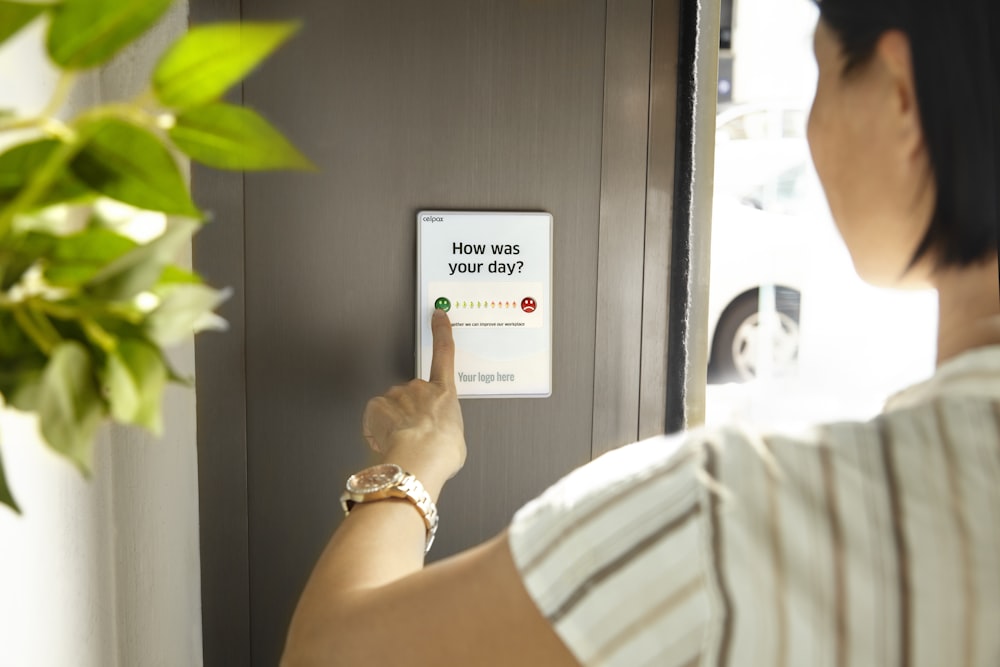 Persona con tarjeta blanca cerca de la planta verde