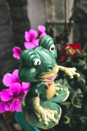 Brightly colored ceramic planter featuring a playful frog design with leafy greenery.