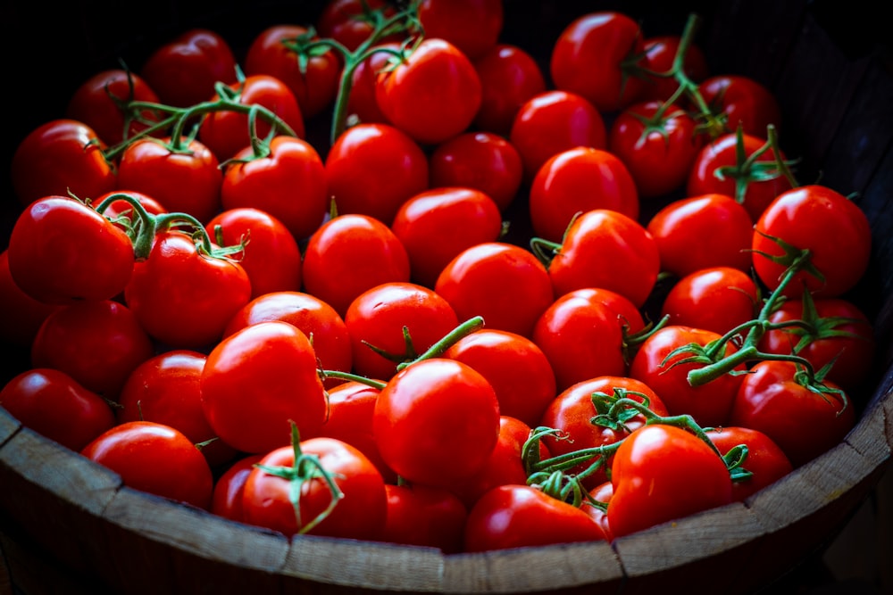 tomates vermelhos na cesta de madeira marrom