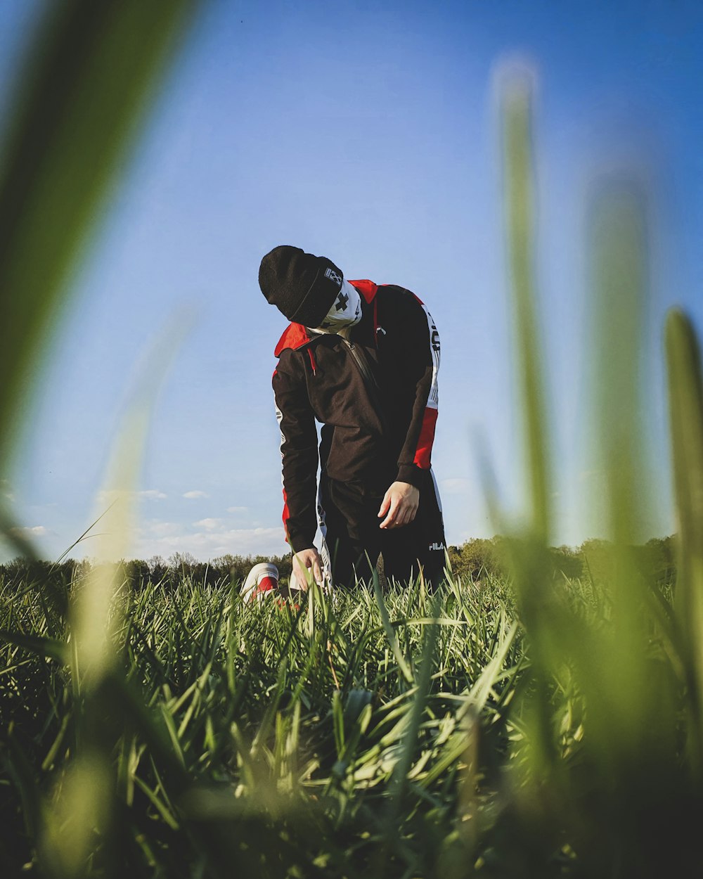 man in black jacket and black pants standing on green grass field during daytime