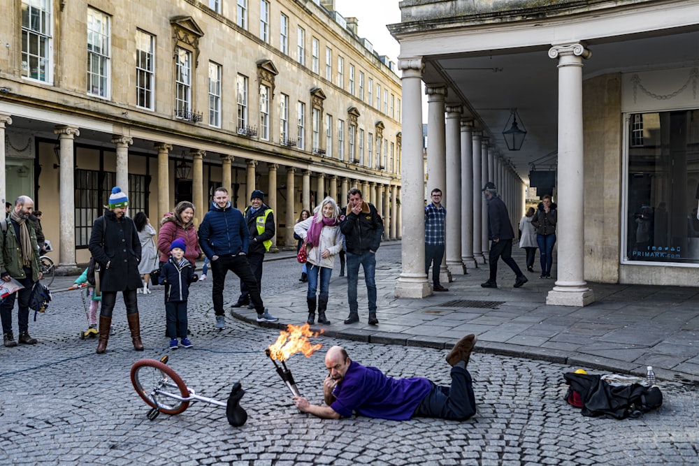 people sitting on sidewalk during daytime