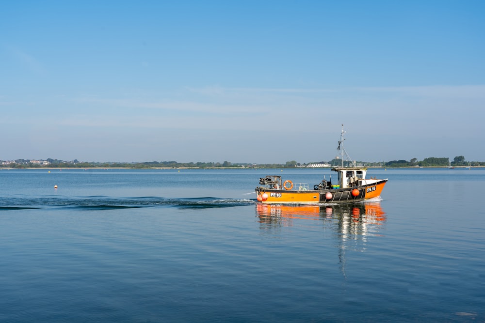 a yellow boat floating on top of a large body of water