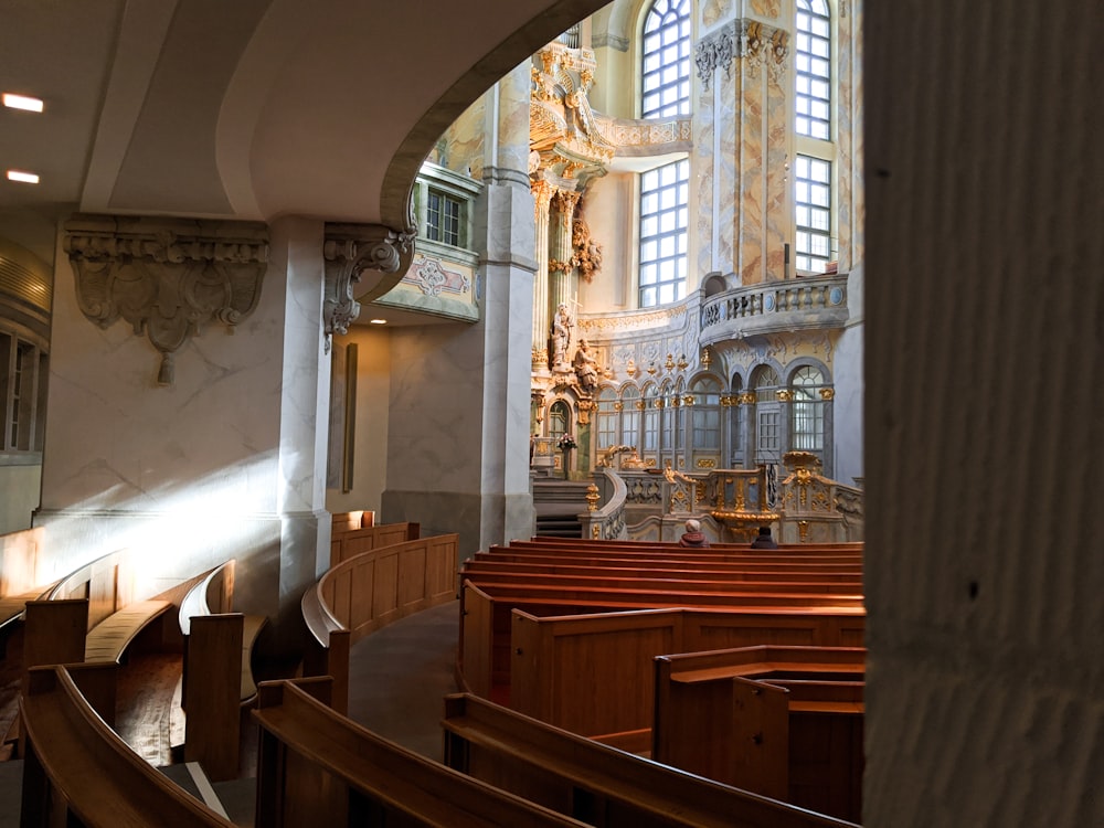 Panca della chiesa in legno marrone all'interno dell'edificio in cemento bianco