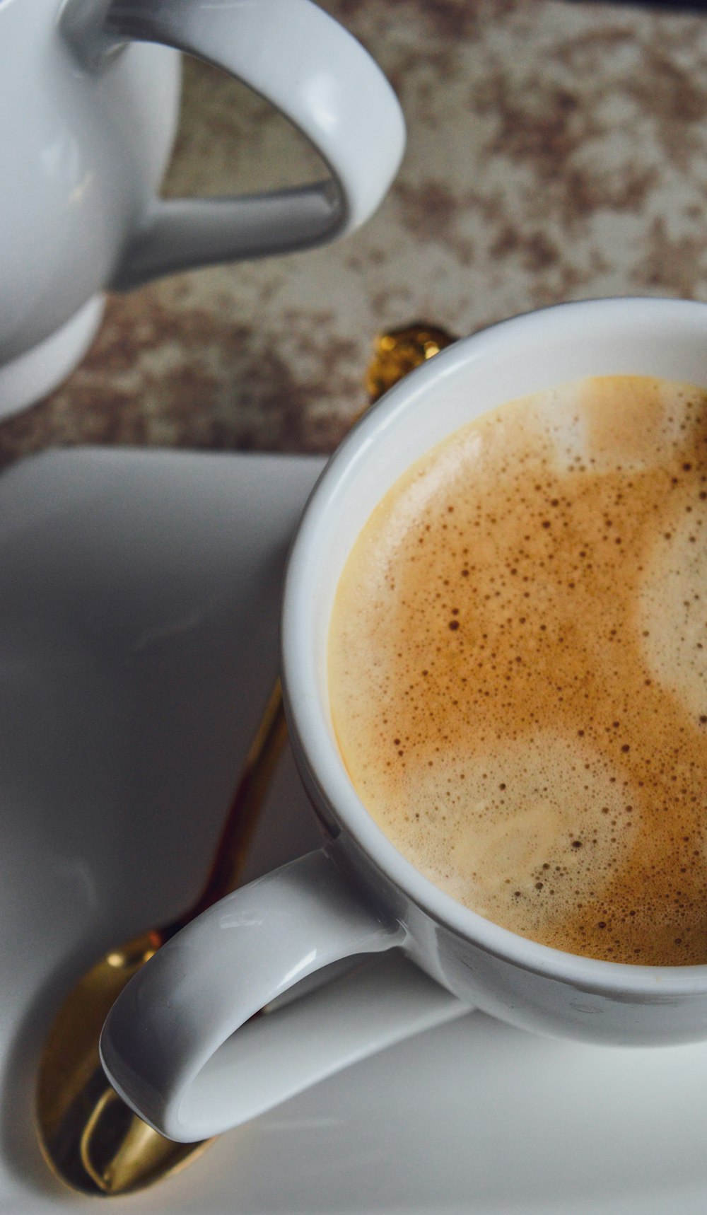 white ceramic mug with brown liquid