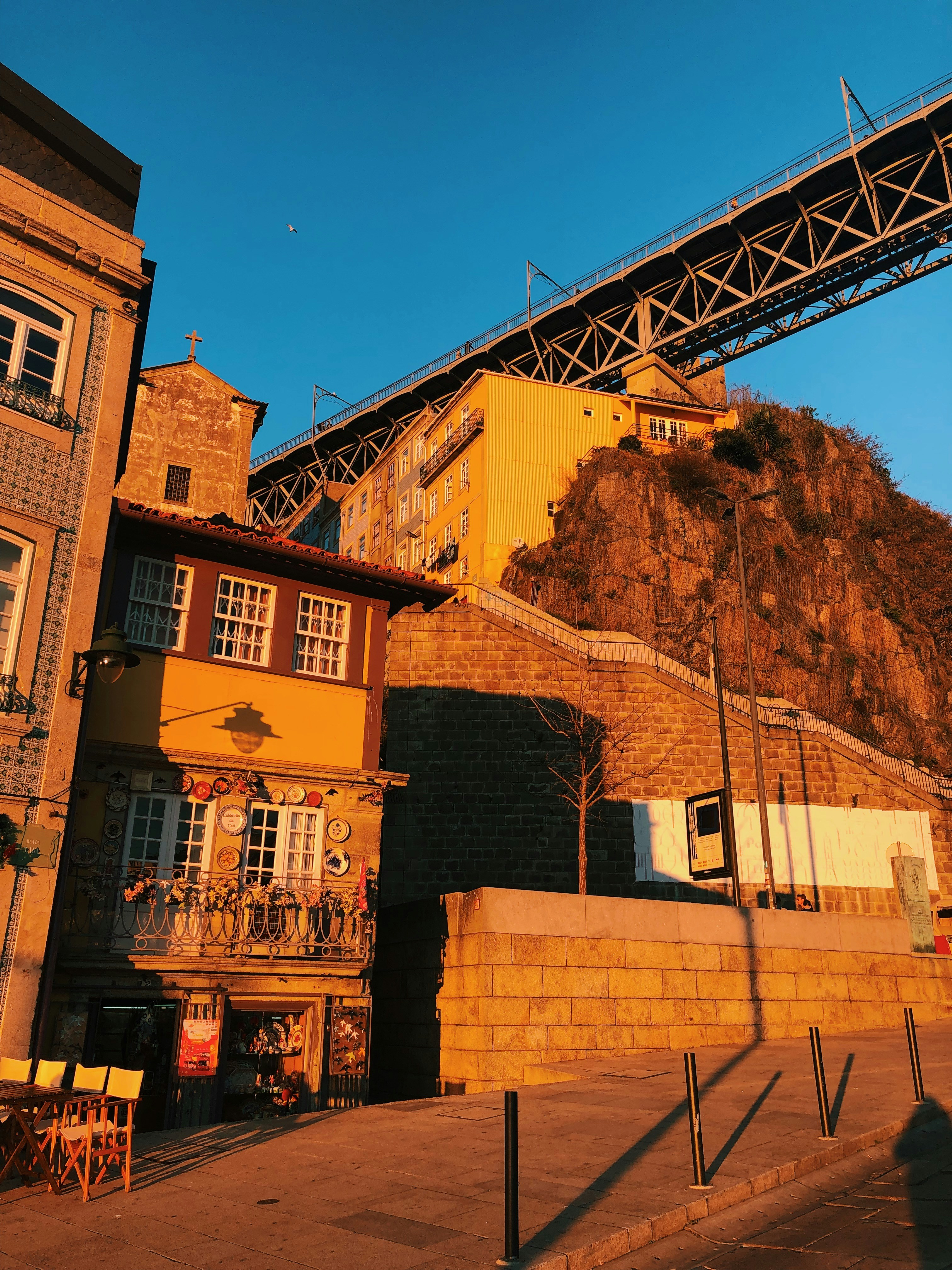 edifício de concreto marrom perto da montanha marrom sob o céu azul durante o dia