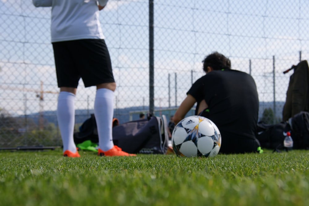 man in black t-shirt and white shorts playing soccer during daytime