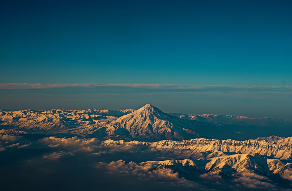 montagne enneigée sous ciel bleu pendant la journée