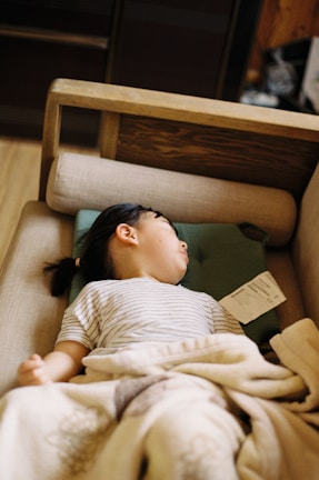 female in white and brown stripe shirt lying on bed