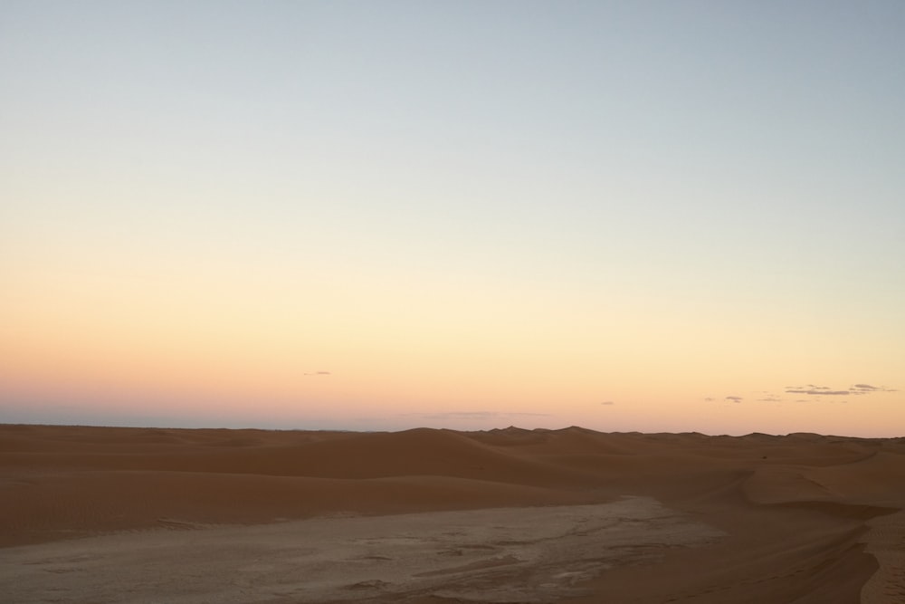 brown sand under orange sky during sunset
