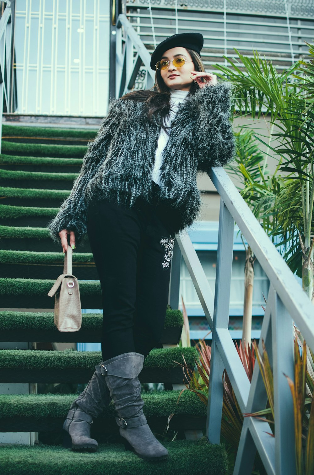 woman in black and white coat and black pants holding brown leather handbag