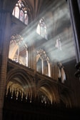 Sunlight streaming through stained glass onto a choir practicing.