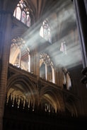 Sunlight streaming through stained glass windows inside the synagogue.