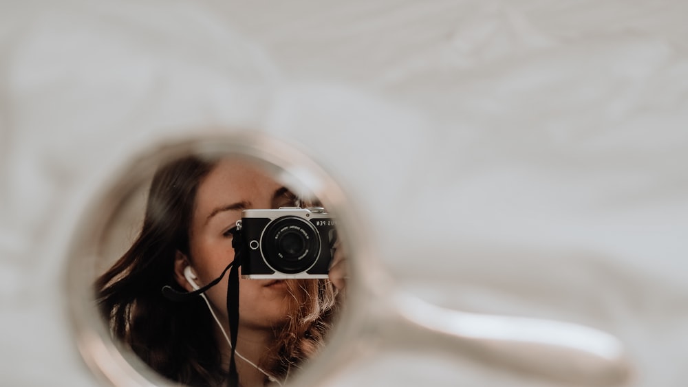 woman in white shirt holding black camera