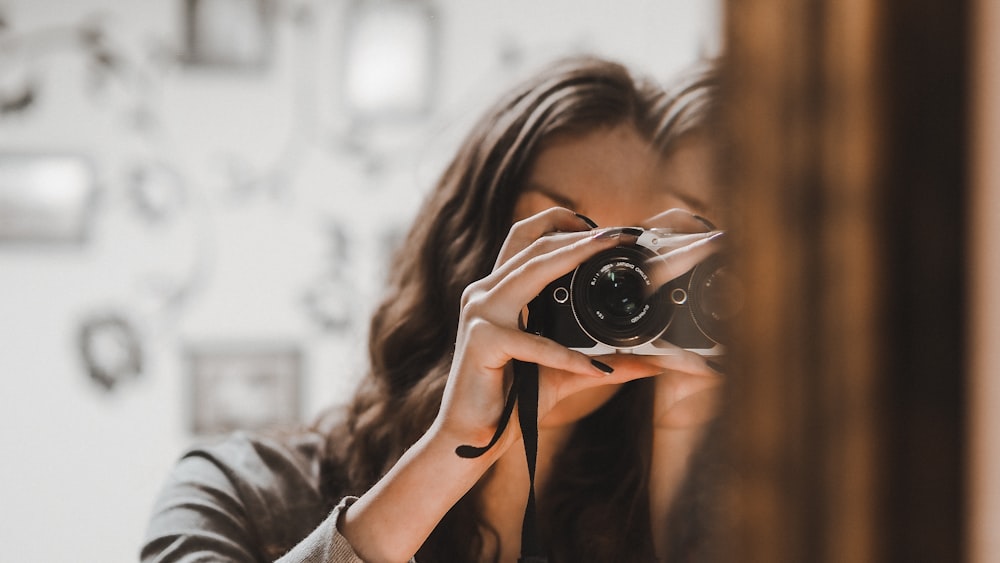 woman in black tank top holding black camera