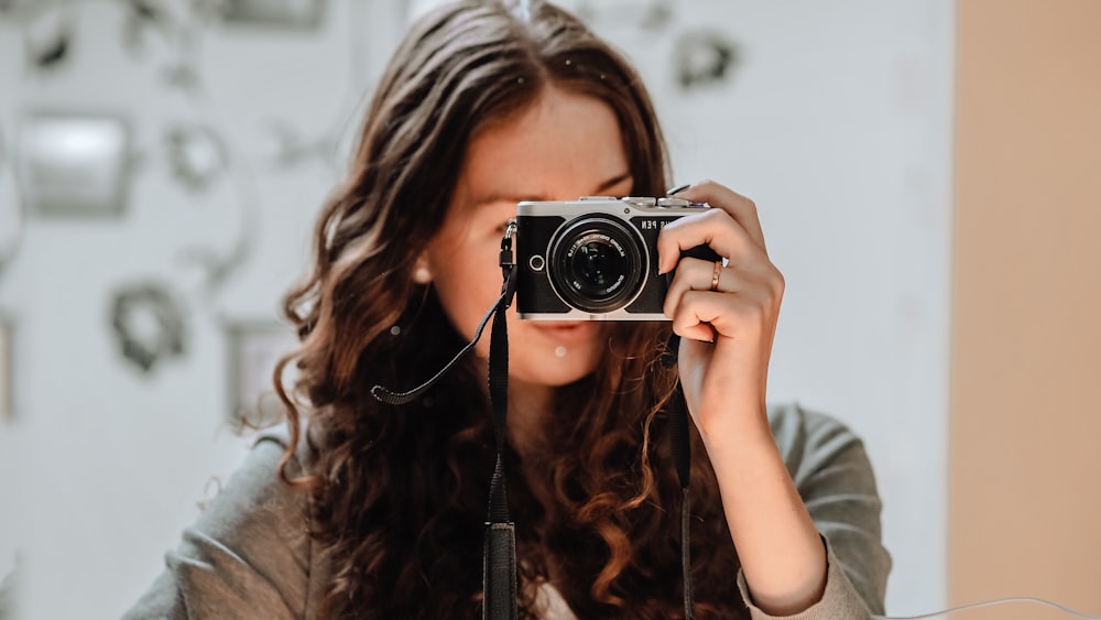 Eine Frau, die ein Foto von sich mit einer Kamera macht