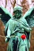 man holding red rose statue