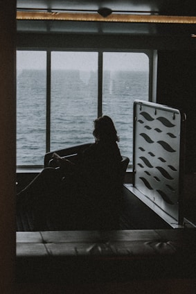 silhouette of person sitting on chair near window