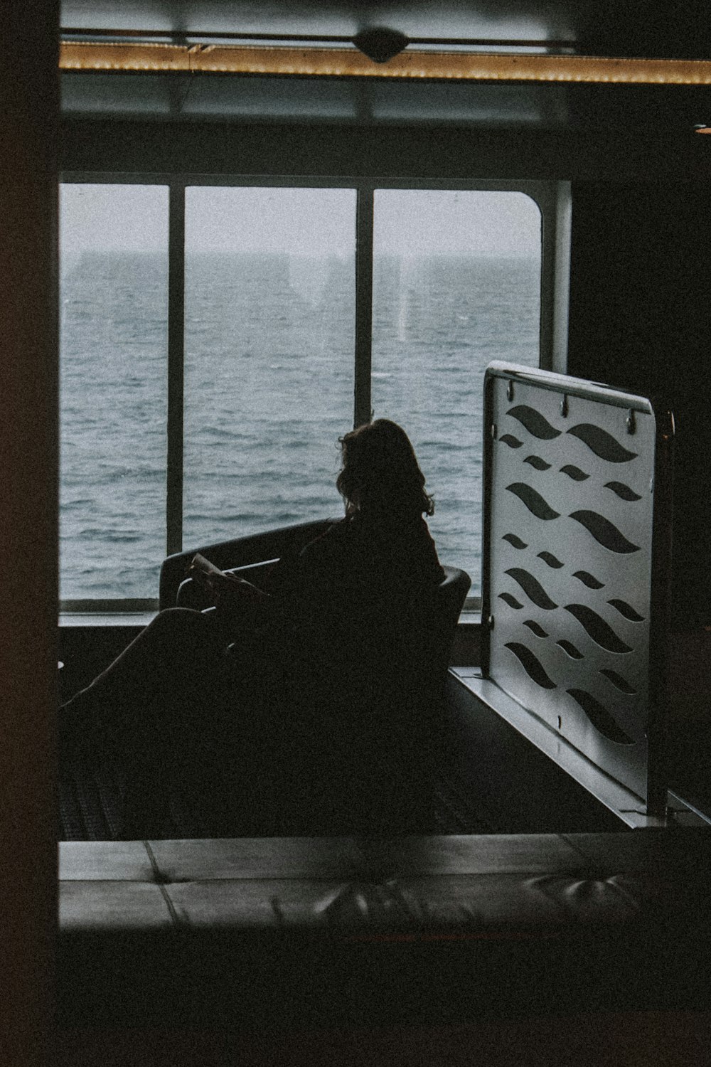 silhouette of person sitting on chair near window