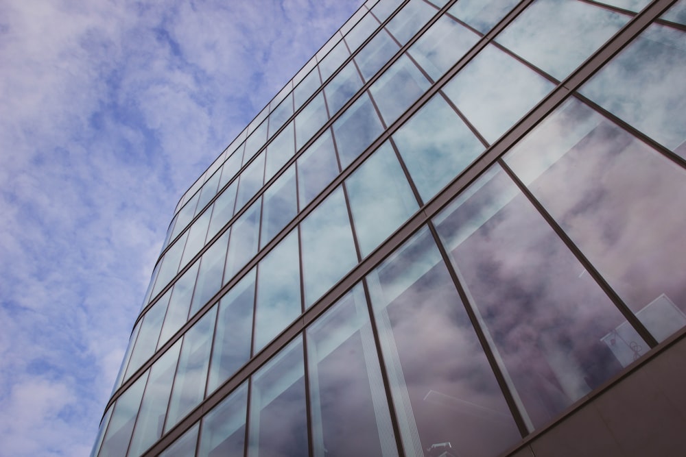 edifício de vidro transparente sob o céu azul