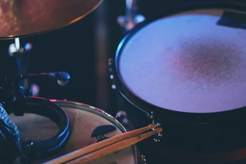 An intimate view of the studio corner with drumsticks resting next to sheet music filled with notes and annotations.