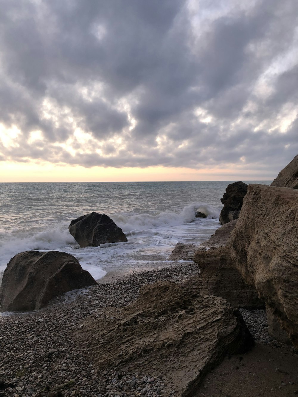 rivage rocheux brun sous ciel nuageux pendant la journée