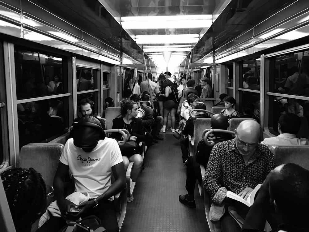 grayscale photo of people sitting on train