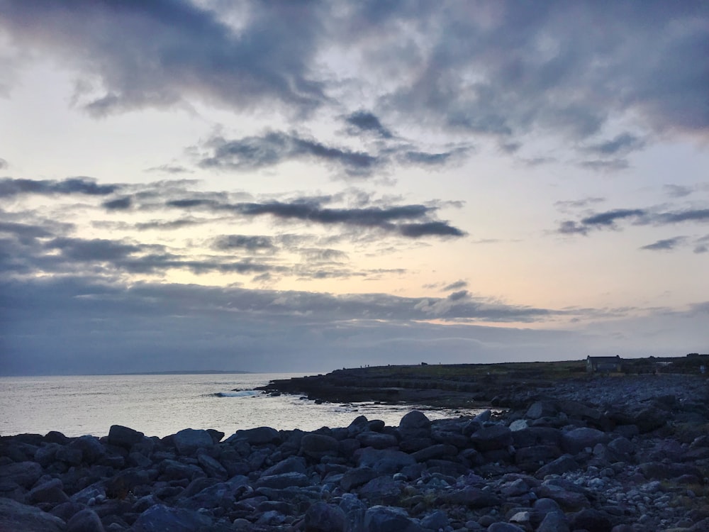 gray rocks near body of water during daytime