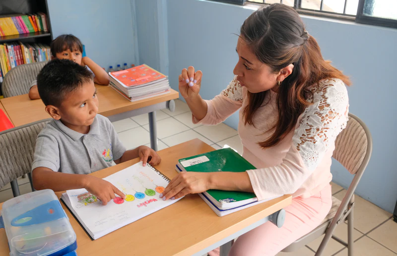 Therapist guiding an Indian child through a workbook activity, one-on-one