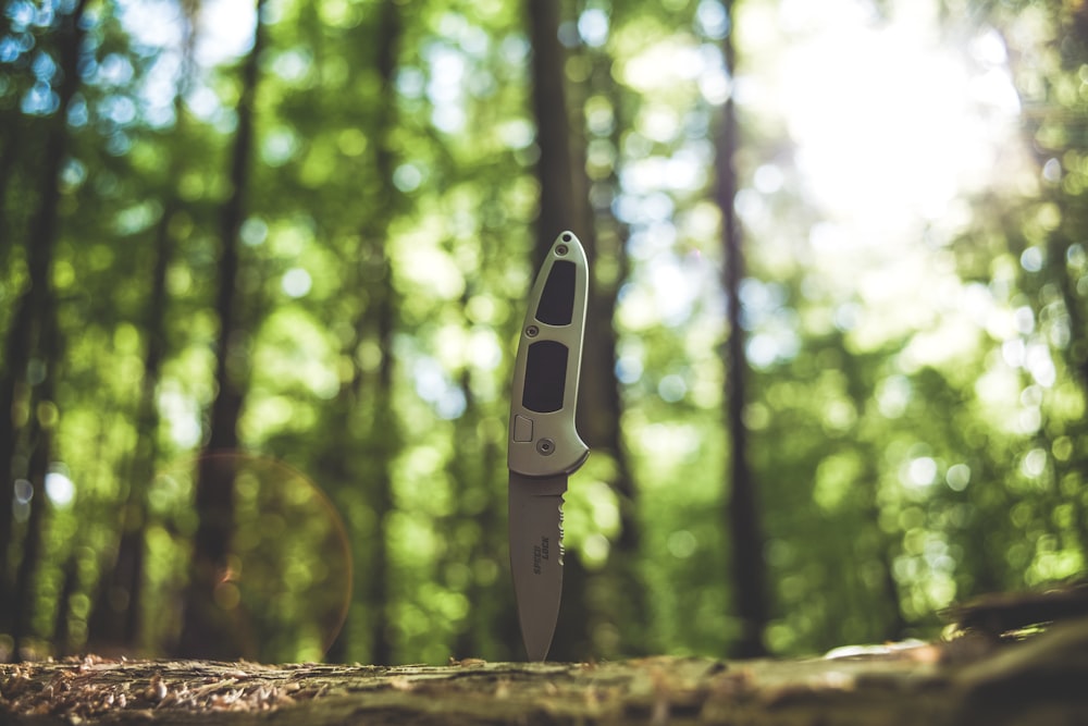 black and white knife on brown tree trunk