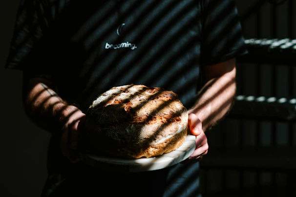 The baker looking both triumphant and haunted, holding a basket of bread with a faint, unsettling glow in the background.