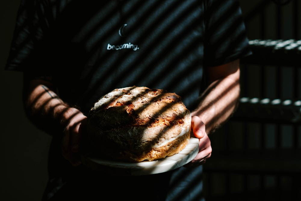 person holding burger on white plate