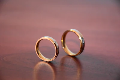 gold wedding band on brown wooden table