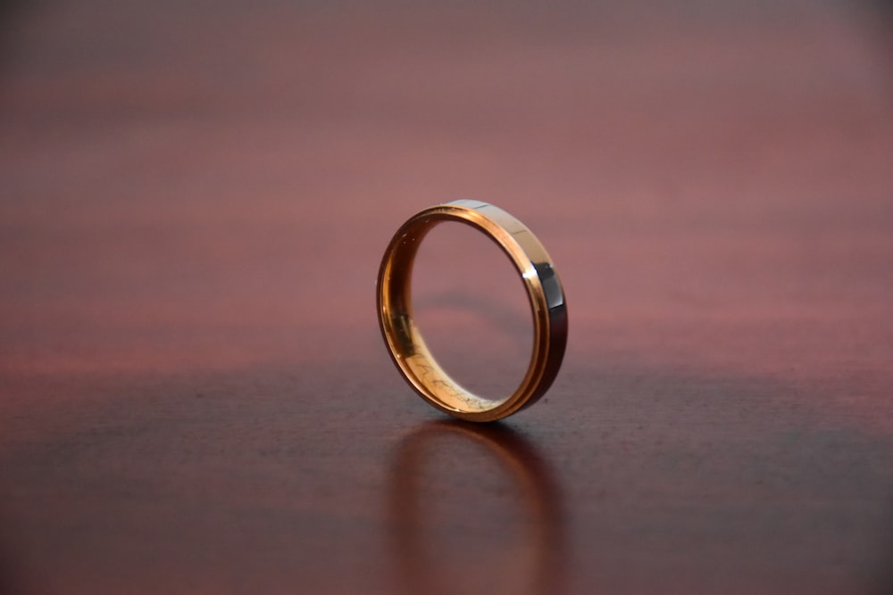 anello d'oro su tavolo di legno marrone