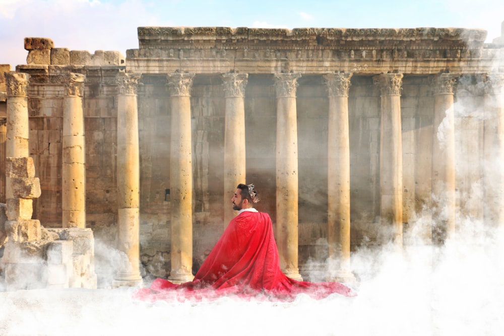 Mujer en vestido rojo de pie cerca de la fuente de agua