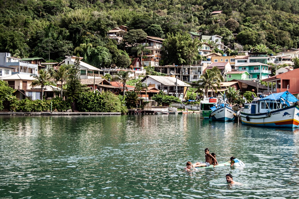 people swimming on lake during daytime