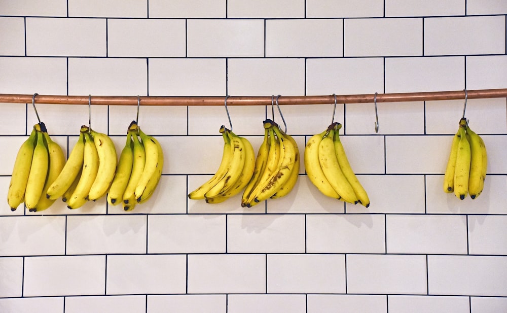 green banana fruit on white brick wall